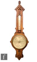 A 19th Century Gothic cased oak barometer by Negretti & Zambra incorporating a thermometer over a