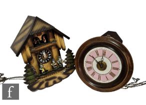 A late 19th Century circular postman's alarm clock, pink enamelled dial and beech frame, and a