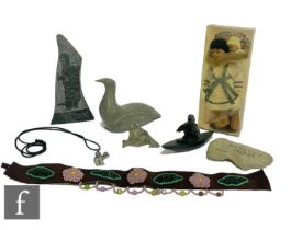 A collection of Inuit related items to include a carved stone block decorated with an Inuit fishing,