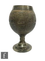 A 19th Century carved coconut cup, silver mounted and on a turned silver stand inscribed '