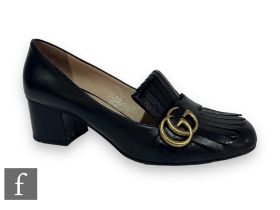 A pair of Gucci black leather mid heel loafers, with black fringe details and overlapping GG in gold