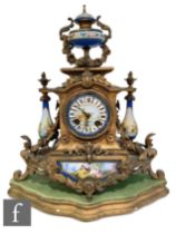 A 19th Century French gilt mantle clock surmounted with an urn over baluster side mounts and