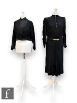 An early to mid 20th Century lady's vintage black silk dress, with high neck finished with button