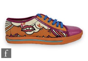 A pair of Marc Jacobs lace up tennis shoes, decorated with pink lips over an abstract orange and