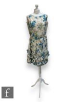 A 1950s/60s lady's vintage sleeveless dress with large blue stylised flowers over a cream ground