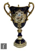 An early 20th Century Coalport three handled chalice with fluted bowl and scroll handles above a