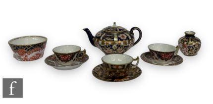 A small collection of Royal Crown Derby porcelain miniatures to include a teapot, three cups and