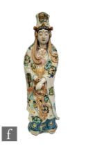 A Chinese late Qing Dynasty famille verte Guanyin, modelled dressed in robes and wearing rosary