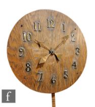 An Arts and Crafts oak circular wall clock, with brass hands and applied Arabic numerals, with New