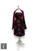 A 1950s lady's vintage dress in black brocade with stylised pink berry and leaf motifs, with