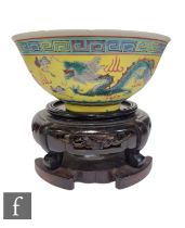 A Chinese famille rose bowl, the yellow ground decorated with wrythen five-clawed dragon amidst fire