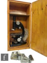 A 20th Century black painted laboratory microscope by CTS, serial number M109434, in stained pine