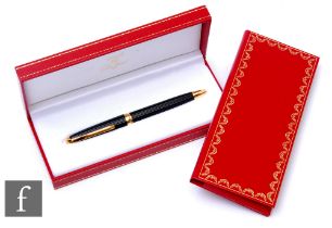 A Must De Cartier black lacquer rollerball pen complete with inner and outer boxes, instruction