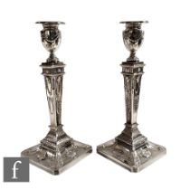 A pair of silver plated Adam's style candlesticks with embossed swags and acanthus leaf details