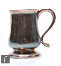 A George II hallmarked silver half pint tankard of plain baluster form terminating in scroll handle,