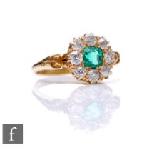 An 18ct emerald and diamond cluster ring, central square cut emerald within a border of eight old