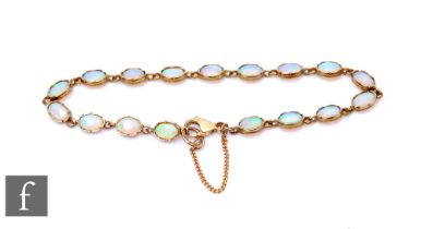 A 9ct opal bracelet comprising seventeen oval collar set opals, total weight 5.4g, terminating in