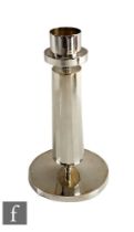 A hallmarked silver candlestick, plain circular base below a faceted column and plain capital,