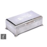 A hallmarked silver rectangular cigarette box with engine turned decoration and a presentation