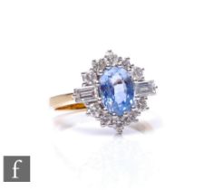 An 18ct sapphire and diamond cluster ring, central oval claw set sapphire flanked by twin baguette