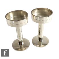 A pair of hallmarked silver candlestick each with a plain spread foot below bark effect column and