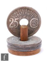 A set of six 1960s French bottle coasters with wooden stand, bearing the date 1924, for 25 Centimes,