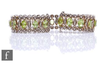 A silver peridot and white sapphire flexible bracelet, twenty one marquise cut peridot spaced and