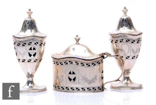 A Queen Anne style hallmarked silver three piece cruet set with pierced and engraved swag