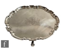 A George II hallmarked silver salver with central engraved crest and initials within stepped pie