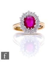 An 18ct ruby and white sapphire cluster ring, central oval ruby, length 8mm, within a border of