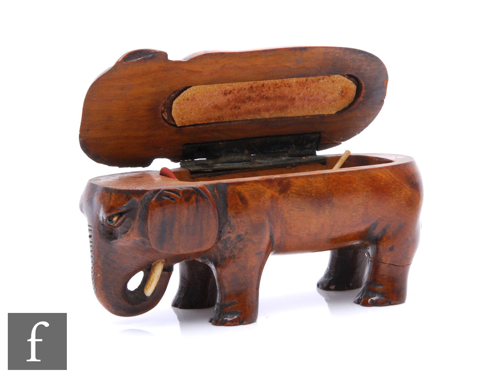 A 19th Century caved sycamore vesta case modelled as a standing elephant, length 10cm, height 5cm.