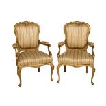 A pair of Louis XV style French giltwood Open Armchairs, with floral crest padded back and arms,