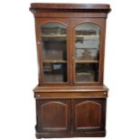 A Victorian mahogany Bookcase, with moulded cornice above two arched and glazed doors, long frieze