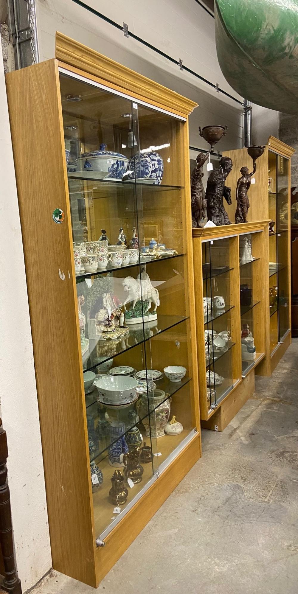 A pair of modern oak framed glass shelved Shop Display Cabinets, together with two similar modern