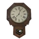 A wooden cased Wall Clock, the circular enamel dial with Roman numerals, and brass pendulum. (1)