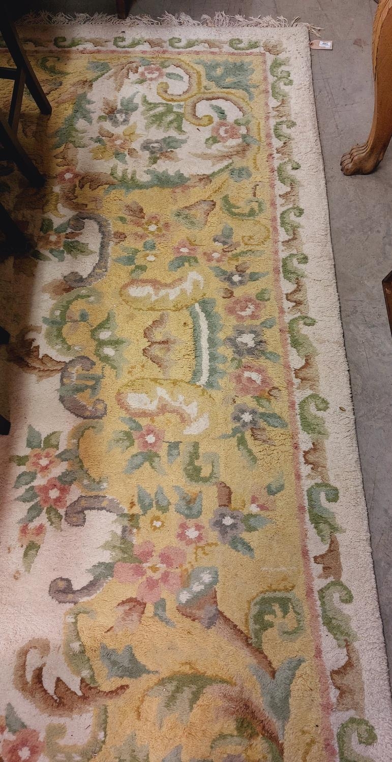 A large cream ground heavy woollen Carpet, with central floral panel and shaped similar decorated