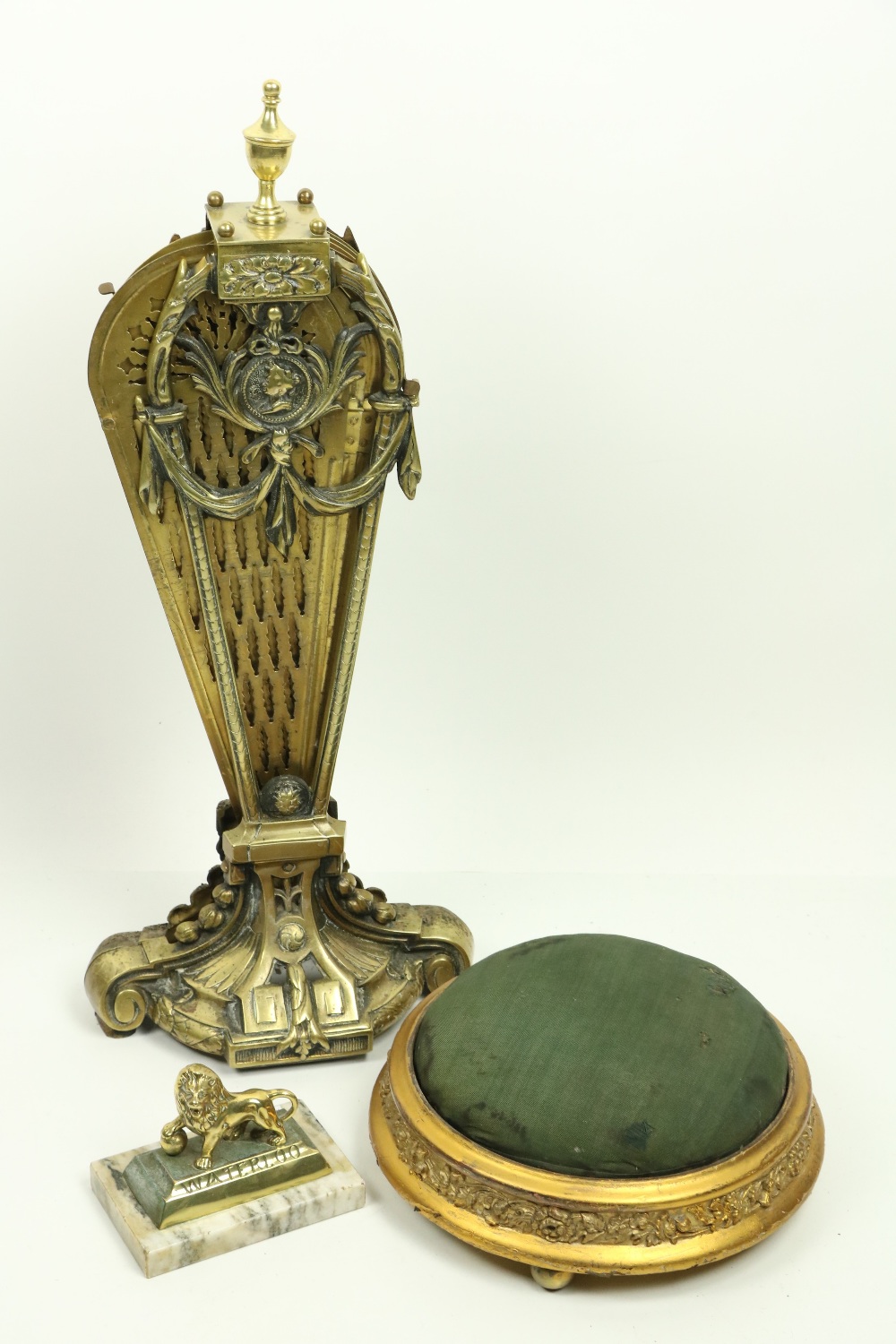 A pierced brass 'peacock' Firescreen, and a small 19th Century circular gilt Footstool, on brass