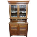 An Edwardian walnut Chiffonier or Cabinet, the moulded cornice above two glazed doors above a vacant