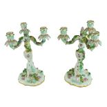 A pair of Meissen three branch Candelabra, with foliate sconces, decorated with flower encrusted