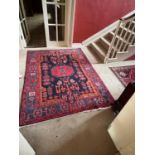 An attractive Afghan Rug, in dark blue and burgundy with a central medallion and all over stylized