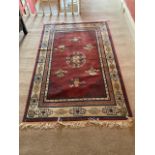 A red ground Chinese wool Carpet, with various medallions inside a beige border, approx. 180cms x
