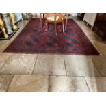 A large Bokhara burgundy ground Rug, with three rows of octagons, and a geometrical conforming