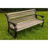 A cast iron Coalbrookdale type Garden Bench, with teak slatted seat and back, the arm rests with