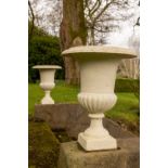 A pair of campanaÿshaped cast iron Garden Urns, each with half reeded body on stem base, 61cms (24")