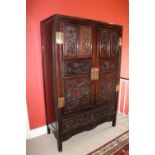 A carved hardwood Cabinet (GUI) Qing Dynasty, of rectangular outline with a pair of hinged doors