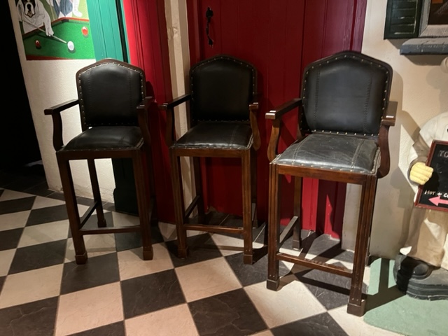 A set of three Armchair Bar Stools, with padded hide back and seat, raised on front fluted