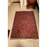 A good burgundy ground Afghan Rug, with two medallions inside conforming border, 152cms x 101cms (