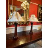 A pair of mahogany and brass mounted Corinthian styleTable Lamps, with cream pleated shades,