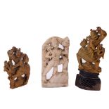 A pair of carved Chinese soapstone Groups, each with warrior, riding a Foo Dog on pierced stand,