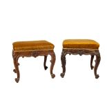 A pair of late Victorian carved oak Footstools, each covered in gold fabric and raised on four